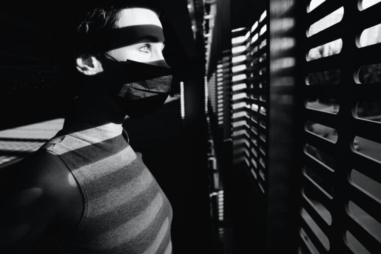 black and white photo of person looking at the window. National Schizophrenia Awareness Day