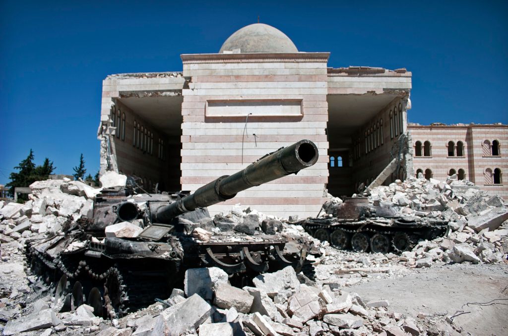 Two destroyed tanks in front of a mosque in Azaz, Syria. Books about Syrian Civil War.