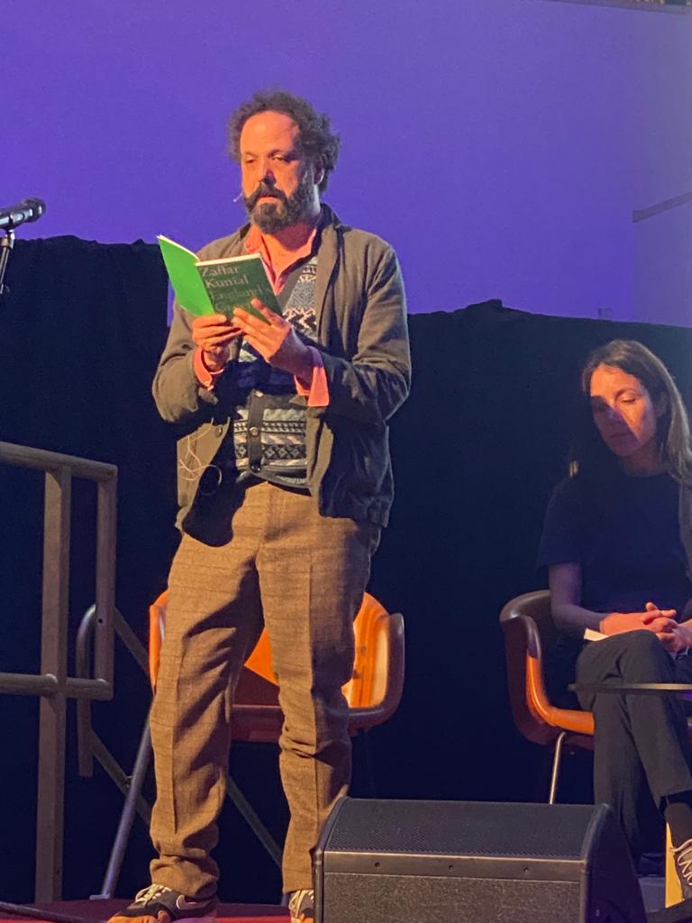 Poet Zaffar Kunial stands to recite poem