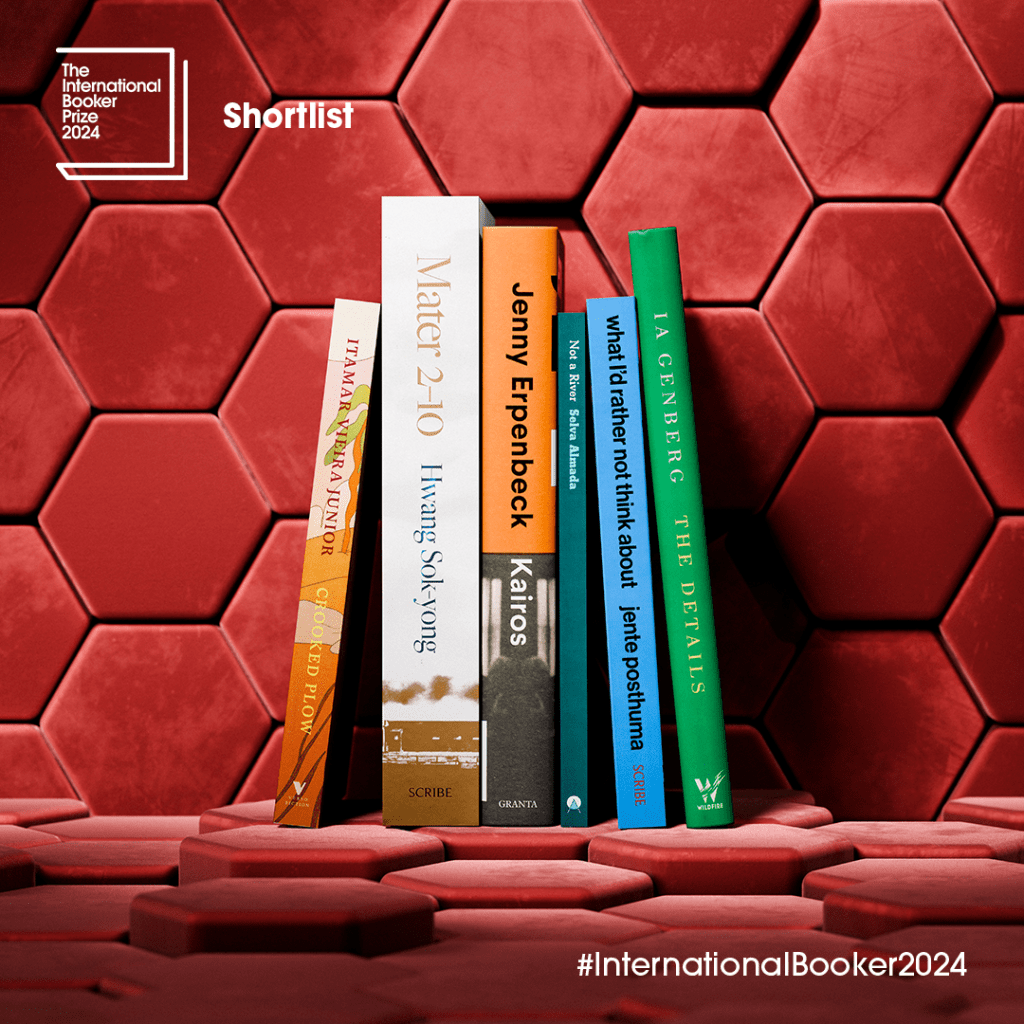 A stack of books on a red hexagonal surface, representing the International Booker Prize 2024 shortlist, with the hashtag #InternationalBooker2024.