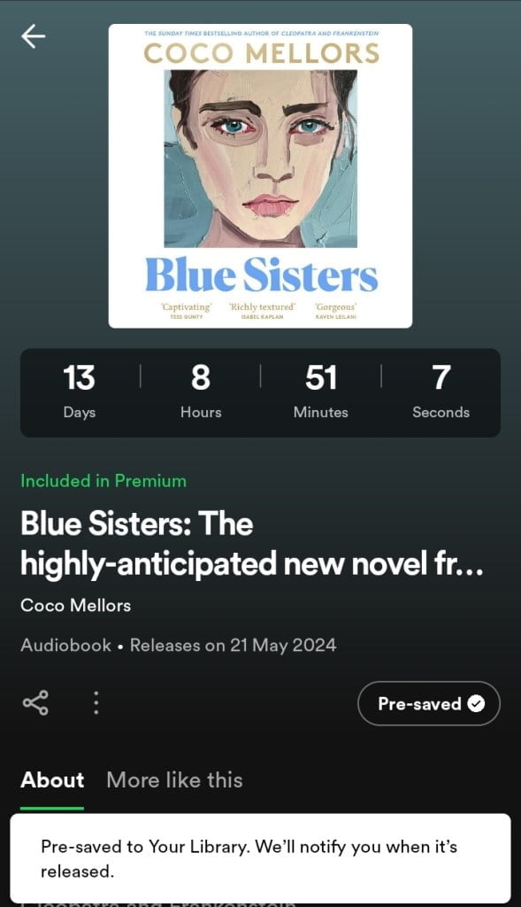 The image shows a screenshot of a Spotify Countdown Page for the audiobook "Blue Sisters" by Coco Mellors. The page features a cover with a stylized portrait of a woman with blue tones. The countdown timer displays 13 days, 8 hours, 51 minutes, and 7 seconds until release. The audiobook is noted as being included in Spotify Premium and has already been pre-saved by the user, as indicated by the pre-saved checkmark. There are tabs labeled 'About' and 'More like this' at the bottom of the page for further navigation.